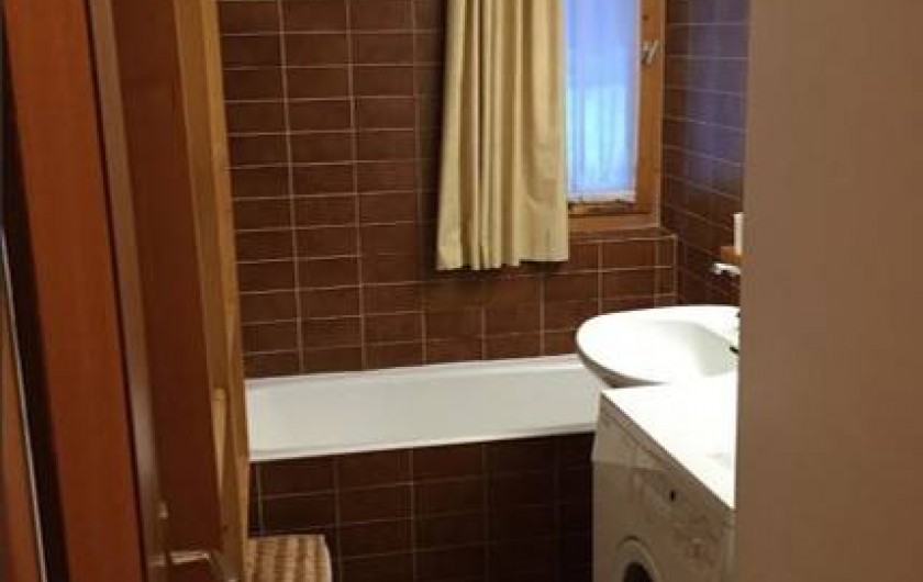 Une salle de bain avec une machine à laver le linge