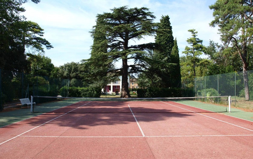 Location de vacances - Appartement à Airoux - le terrain de tennis, dominé par son cèdre