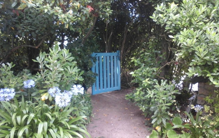 La barrière bleue ouverte sur les agapanthes fleuries.  au POULDU