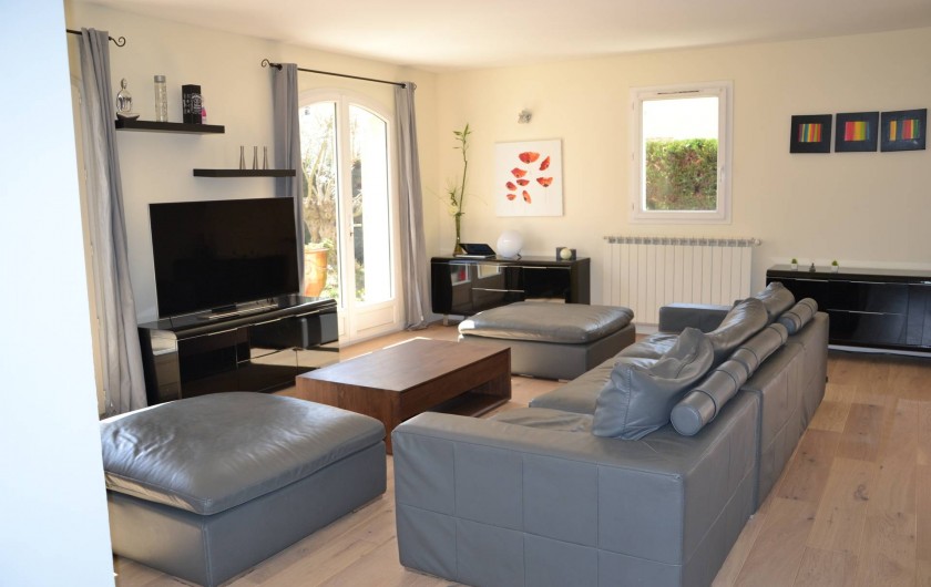 Location de vacances - Villa à Aix-en-Provence - Salon - Grand canapé 8 places avec 2 poufs, meubles et TV UHD - parquet en bois