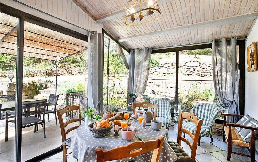 Location de vacances - Villa à Vezac - Véranda vue sur le bassin à carpes et sa terrasse couverte.