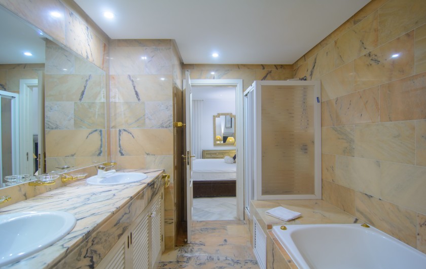 Location de vacances - Appartement à Marbella - Douche à l'italienne, baignoire, double lavabo dans la salle de bain.