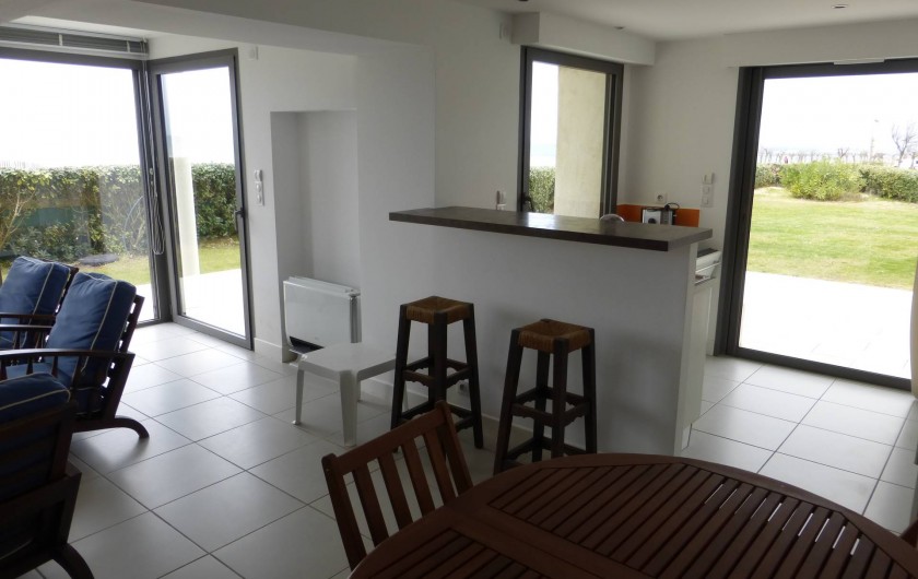 Location de vacances - Appartement à Soorts-Hossegor - appartement n°2: : coin repas ; cuisine derrière le bar donnant sur le jardin