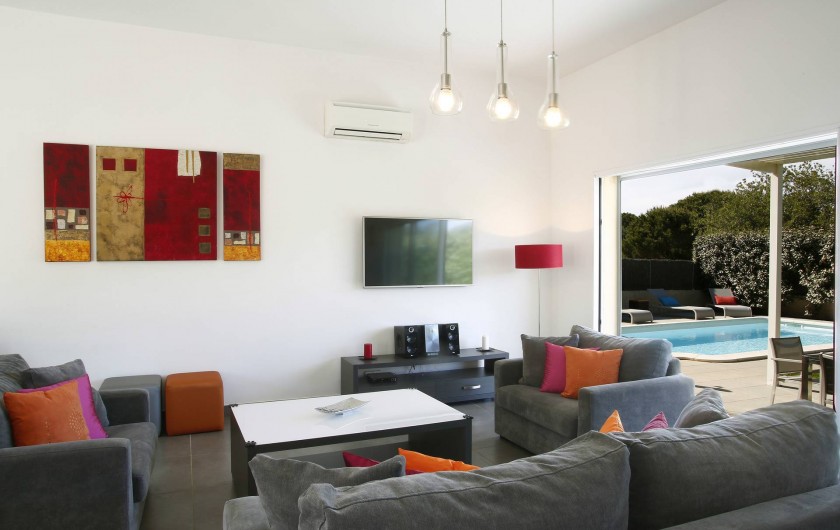 Location de vacances - Villa à Calvi - Salon avec vue sur la terrasse et la piscine.