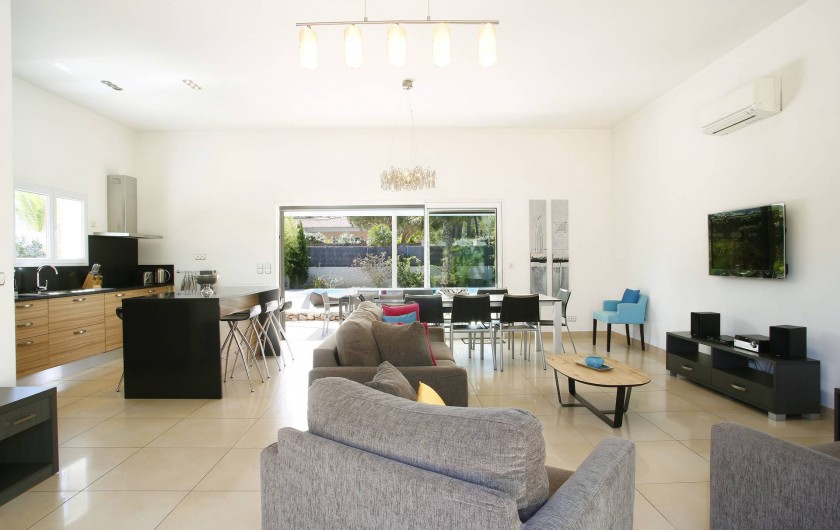 Location de vacances - Villa à Calvi - Salle de séjour et cuisine ouverte, avec vue sur la piscine