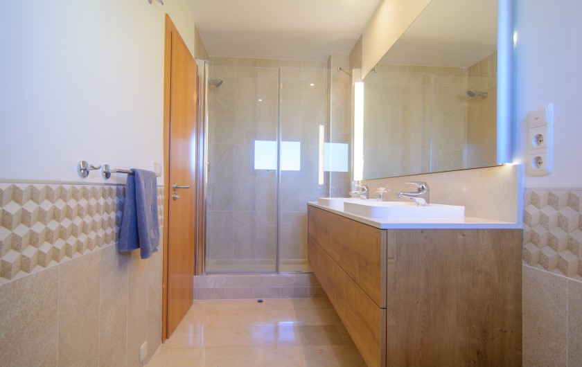 Salle de bain attenante avec double lavabo et douche à l'italienne.