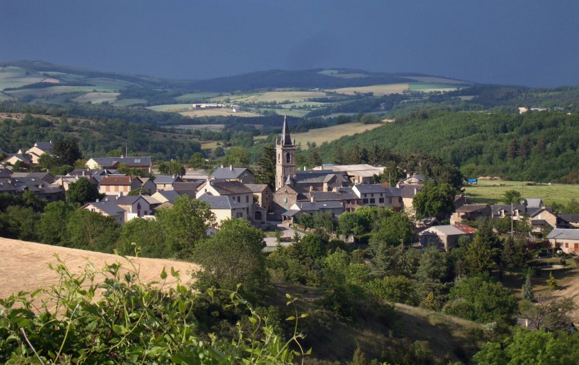 Location de vacances - Chambre d'hôtes à Saint-Laurent-de-Lévézou - Vue sur le village St Laurent de Lévézou au détour d'un chemin