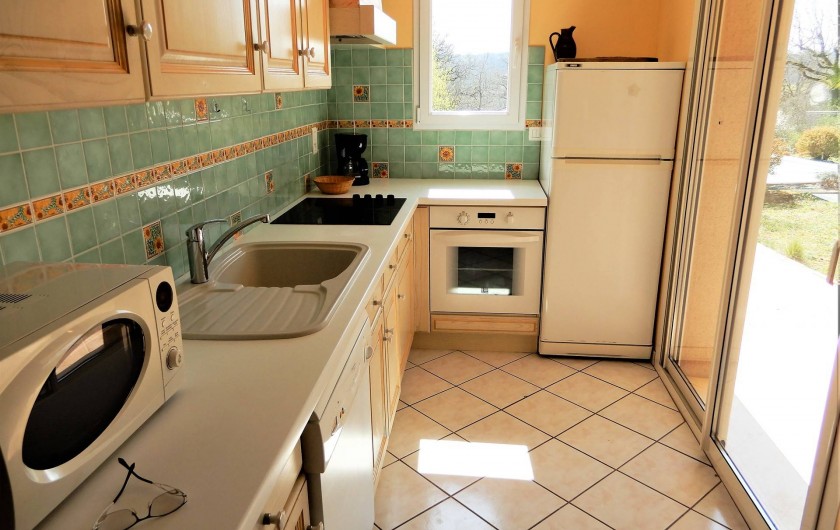 Location de vacances - Villa à Loubressac - Cuisine avec baie vitrée sur la terrasse couverte