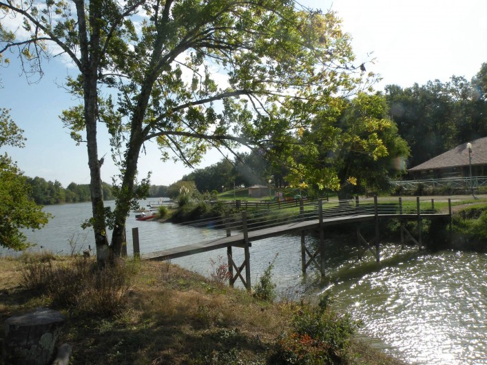 Location de vacances - Chalet à Bretagne-d'Armagnac - CHALET GUZET Vue depuis l'île sur bâtiment snack bar jeux et port