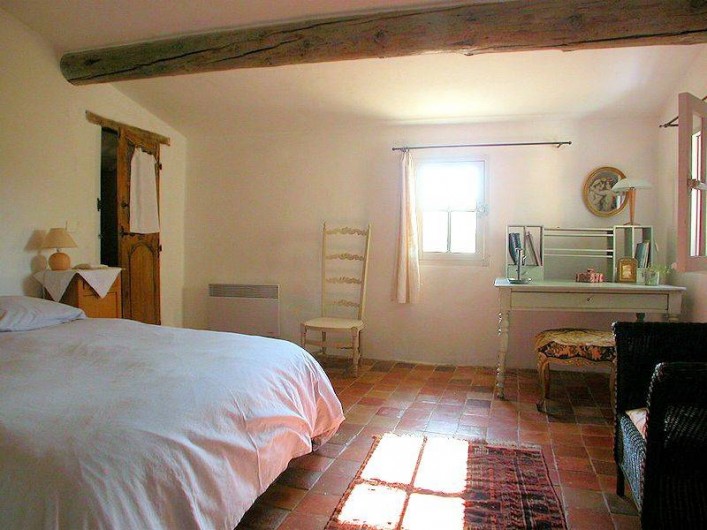 Location de vacances - Maison - Villa à Rustrel - Une des  chambres avec ses poutres peintes et ses sols anciens
