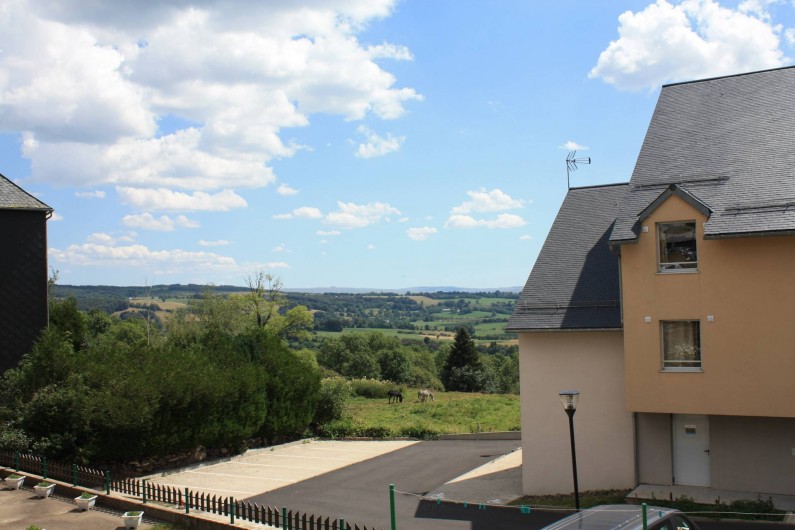 Location de vacances - Studio à Picherande - Vue campagne de la rue avec extrémité bâtiment B