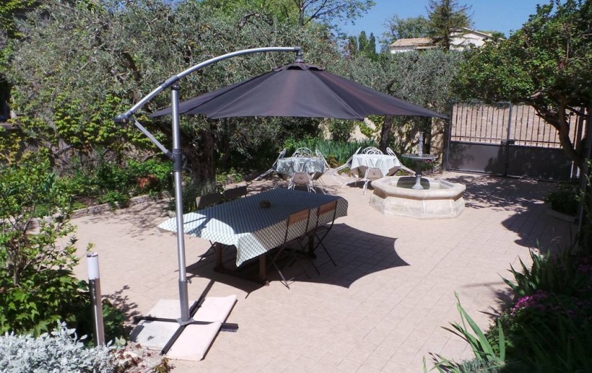 Location de vacances - Villa à Bezouce - Terrasse du gîte avec sa grande table, son parasol et deux salons de jardin
