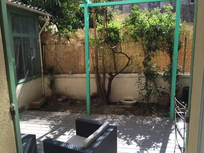 Location de vacances - Appartement à Marseille - Cour extérieure privative aménagée : terrasse en bois, salon, table
