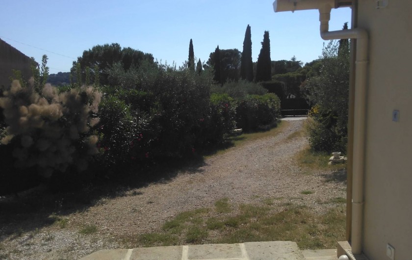 Location de vacances - Chalet à Vergèze - vue ouest de la terrasse sur le jardin+portail