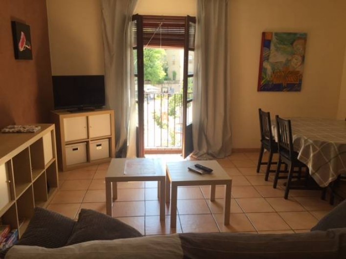 Location de vacances - Appartement à Besalú - Salle à manger avec une table avec sis chaises, le canapé et la TV.