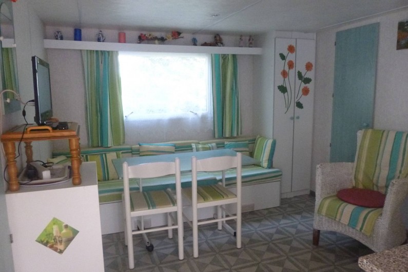 Location de vacances - Bungalow - Mobilhome à Hyères - salon - chambre  2 lits derrière fauteuil porte verte