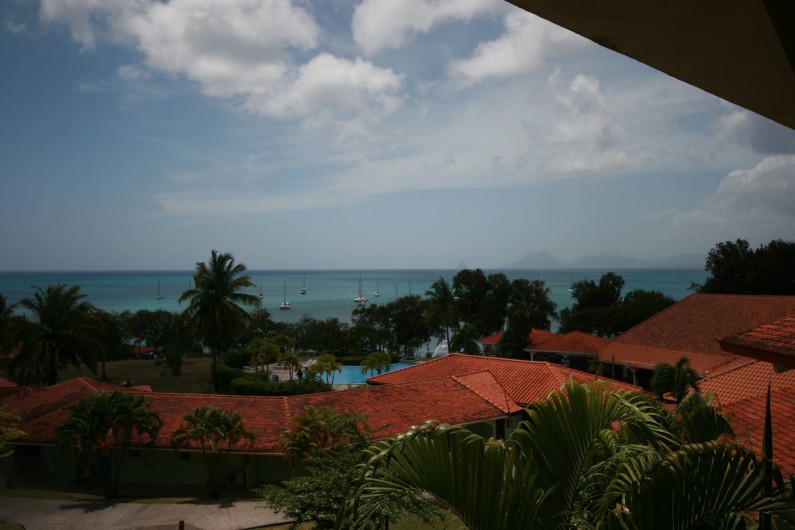 Location de vacances - Appartement à Sainte-Anne - Vue depuis le balcon sur le jardin, la piscine et la mer