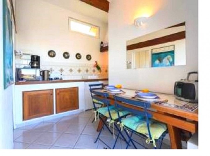 Location de vacances - Studio à Cagnes-sur-Mer - Vue cuisine américaine equipée avec la table à manger du studio Francy