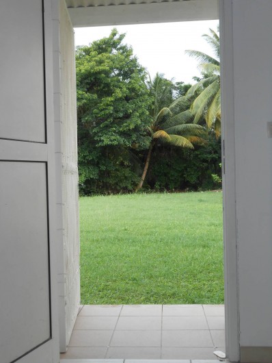 Location de vacances - Appartement à Les Trois-Îlets - vue jardin depuis le canapé, transats disponibles