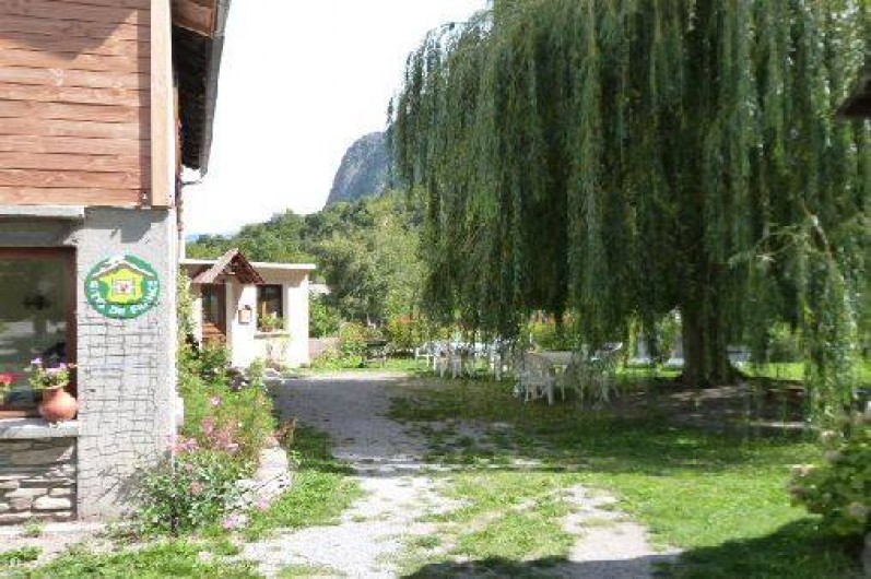 Location de vacances - Gîte à Saint-Clément-sur-Durance - Au fond, l'entrée du gîte. Salon de jardin sous le saule pleureur.
