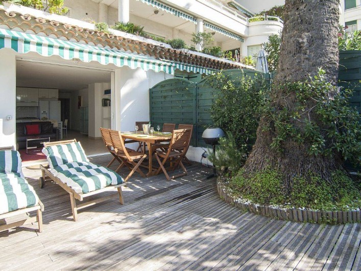 Location de vacances - Appartement à Cannes - Le jardin / terrasse : coin chaises longues, coin repas avec BBQ