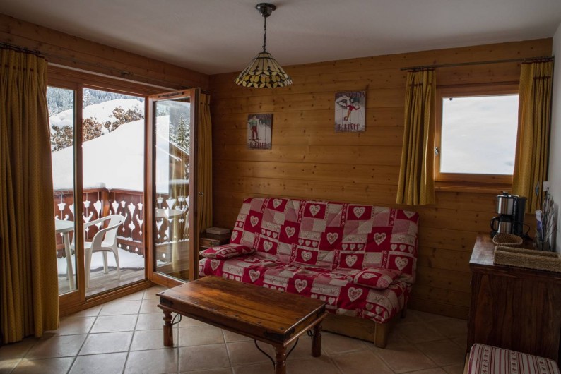 Location de vacances - Appartement à Les Carroz d'Arâches - canapé lit salon + vue sur terrasse