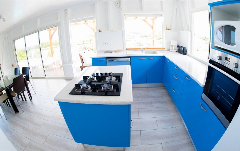 Location de vacances - Villa à Sainte-Anne - cuisine US ouverte sur le salon et sur la terrasse extérieure