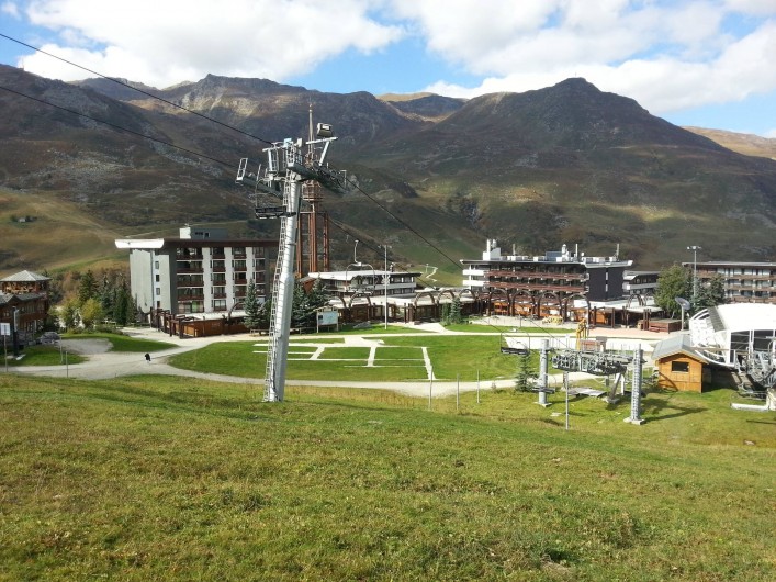 Location de vacances - Appartement à Les Menuires - Vue d'ensemble de la Croisette avec l'immeuble à gauche du pylone