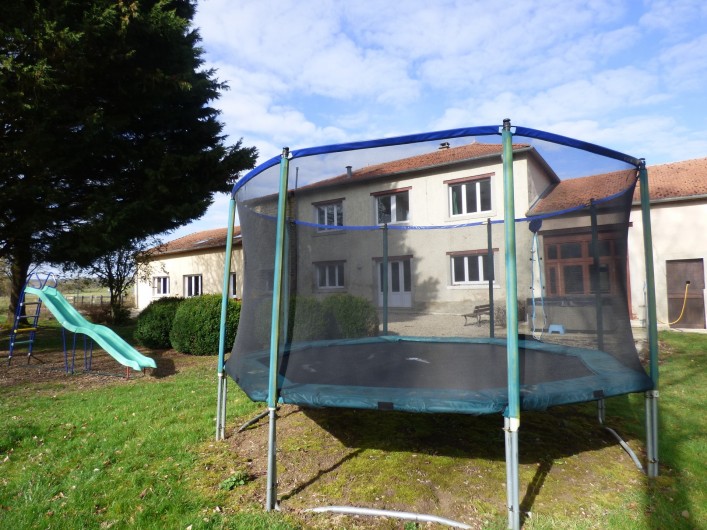 Location de vacances - Gîte à Nouart - trampoline et toboggan à l'arrière du gîte