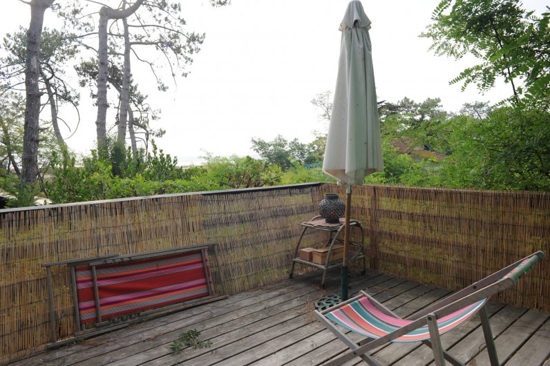 Location de vacances - Chalet à Le Cap Ferret - Coin droit de la terrasse , parasol chaises longues .