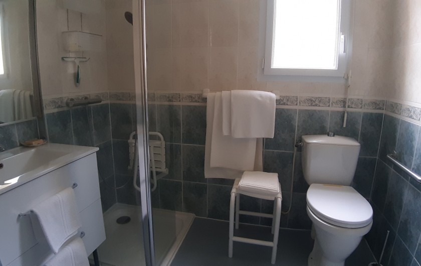 Salle de douche avec sièges et toilette haute