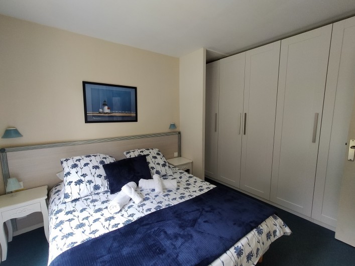Location de vacances - Appartement à Cabourg - Vue de la chambre. Mur du fond équipé de rangements et penderie