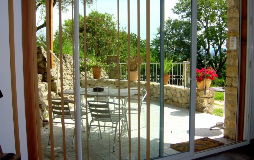 Location de vacances - Gîte à La Garde-Adhémar - Vue sur la terrasse depuis l'intérieur du gîte