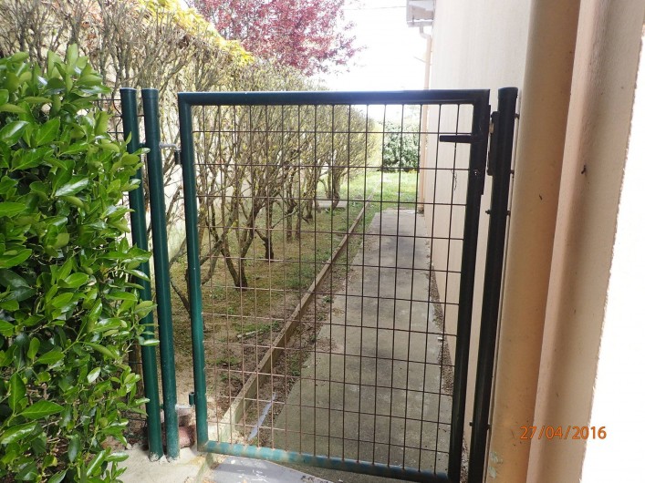 Location de vacances - Villa à Saint-Hilaire-de-Riez - passage sur le côté de la maison, un portillon fermé,  avec une clé