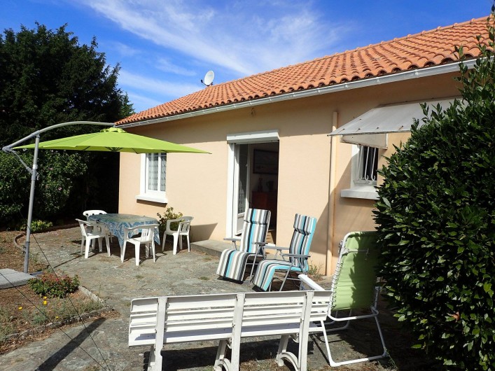 Location de vacances - Villa à Saint-Hilaire-de-Riez - terrasse côté jardin avec son salon de jardin son parasol et ses transats