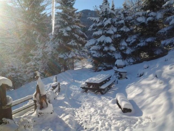 Location de vacances - Chalet à Saint-Gervais-les-Bains - Coté jardin sous la neige : tables, bancs, barbecue