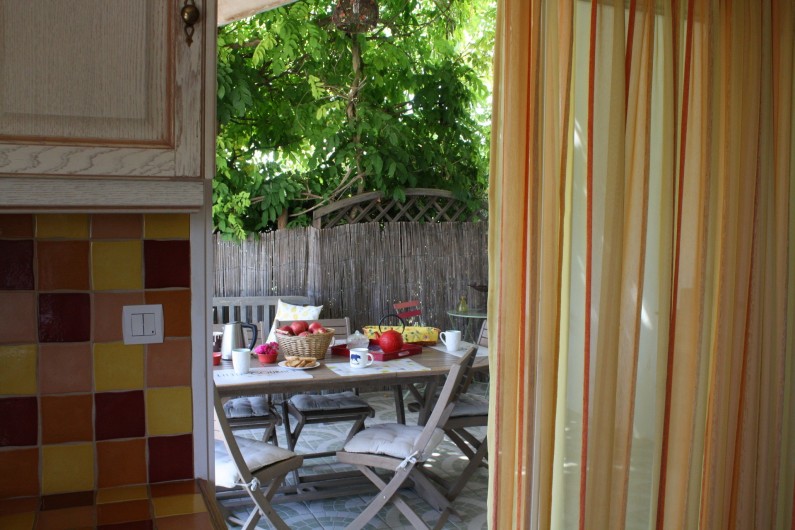 Location de vacances - Gîte à Lafrançaise - Accès de la cuisine à la terrasse ombragée par une glycine.