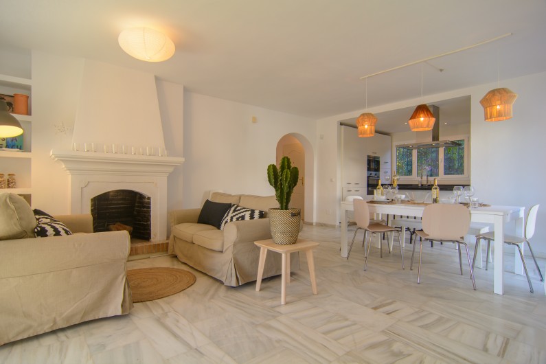 Location de vacances - Villa à Marbella - Salle de séjour avec carreaux de marbre, cheminée et table
