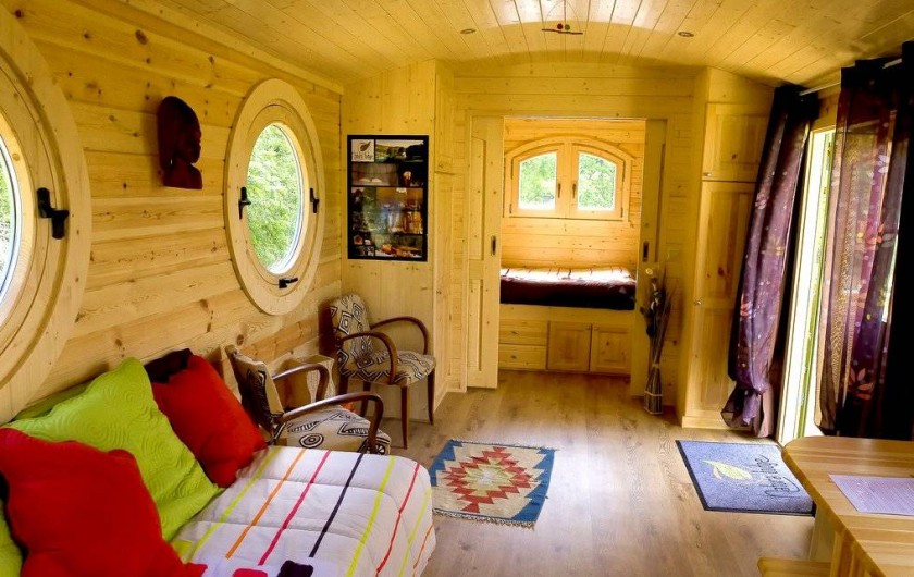 Location de vacances - Yourte à Barjac - Vaste intérieur confortable et chaleureux d'une roulotte en bois pour 2-4 pers
