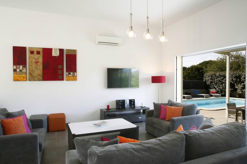 Location de vacances - Villa à Calvi - Salon avec vue sur la terrasse et la piscine.