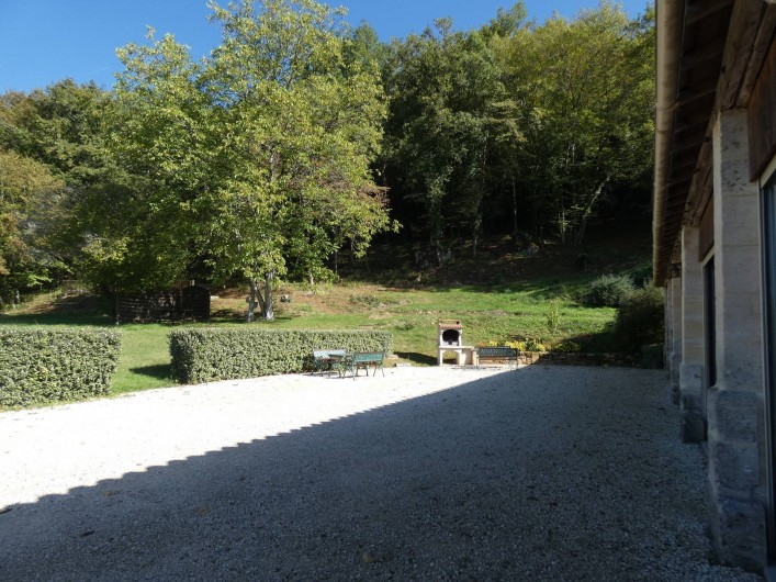 Location de vacances - Gîte à Tursac - terrasse devant le gîte avec le barbecue et ses tables