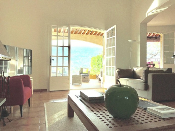 Location de vacances - Villa à Peymeinade - salon/salle à manger. Vue sur terrasse couverte