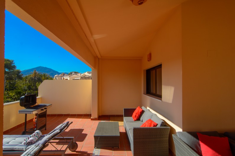 Location de vacances - Appartement à Marbella - Coin salon sur la terrasse avec canapés, table basse et chaises longues.