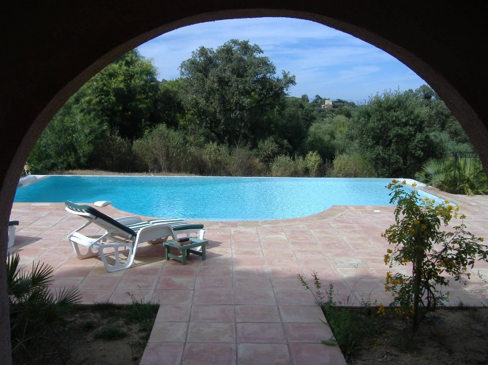 Location de vacances - Villa à Ramatuelle - Vue de la piscine depuis la terrasse couverte du bas.