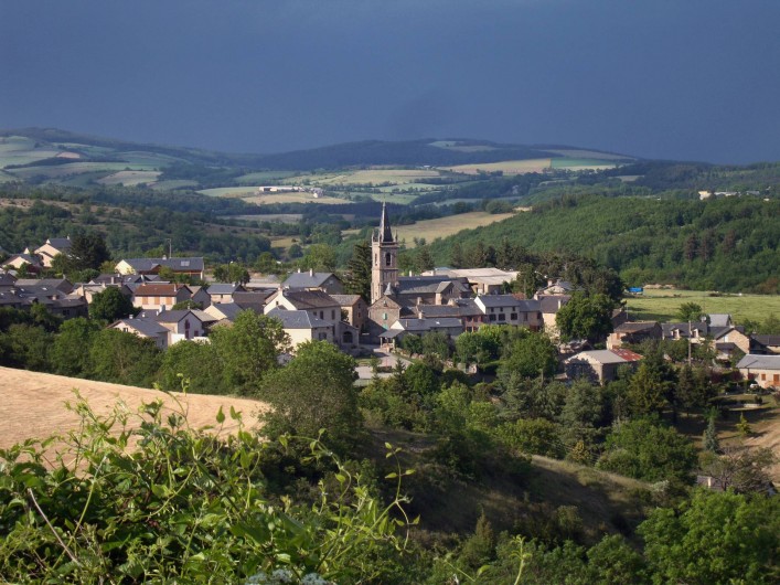 Location de vacances - Chambre d'hôtes à Saint-Laurent-de-Lévézou - Vue sur le village St Laurent de Lévézou au détour d'un chemin