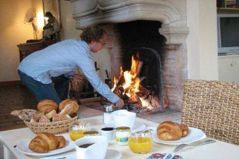 Location de vacances - Chambre d'hôtes à Beaune - Vincent prépare le petit déjeuner au bord de la cheminée, en hiver.