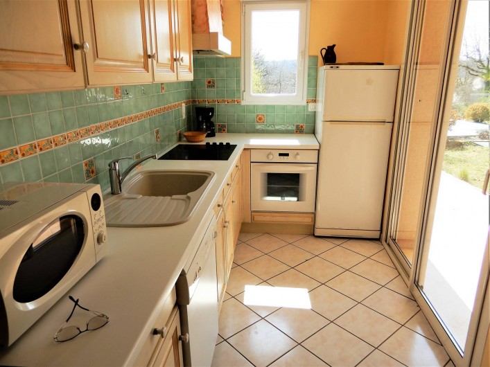 Location de vacances - Villa à Loubressac - Cuisine avec baie vitrée sur la terrasse couverte