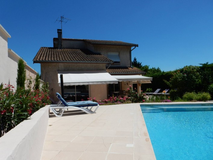 Location de vacances - Villa à Caluire-et-Cuire - le mur au lauriers rose et les stores de la maison