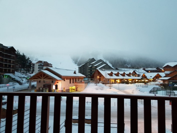 Location de vacances - Appartement à La Joue du Loup - Vue du balcon soir d'hiver, en face les pistes et les commerces