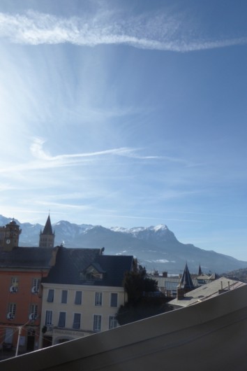 Location de vacances - Appartement à Embrun - Vue du séjour (au printemps!) : place de la Mairie, cathédrale et montagne